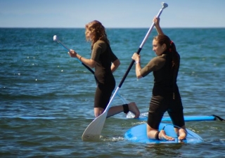 Chicas de rodillas en las tablas de sup